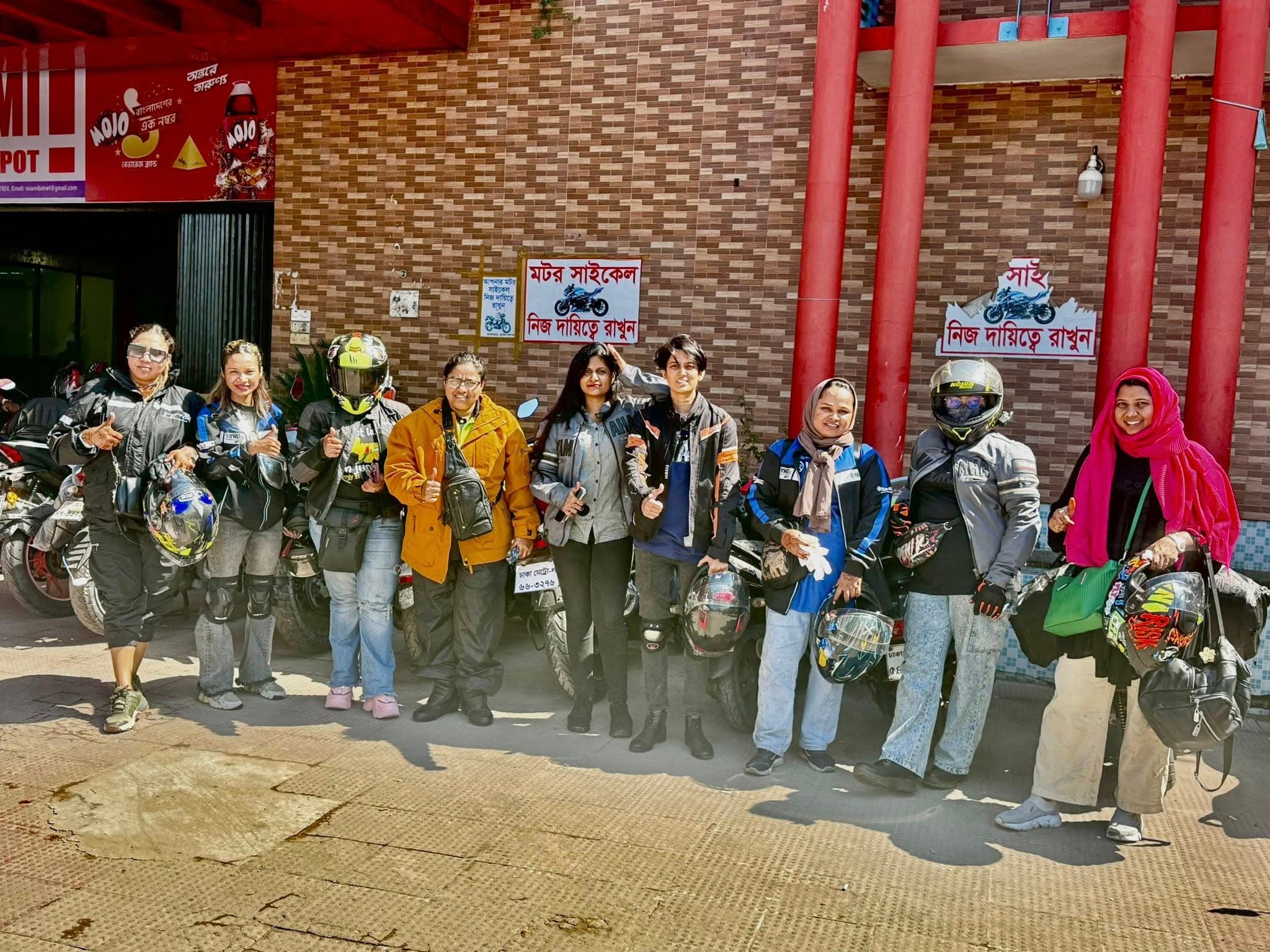 Riders and motorcycles paused at a roadside stop on a group tour.