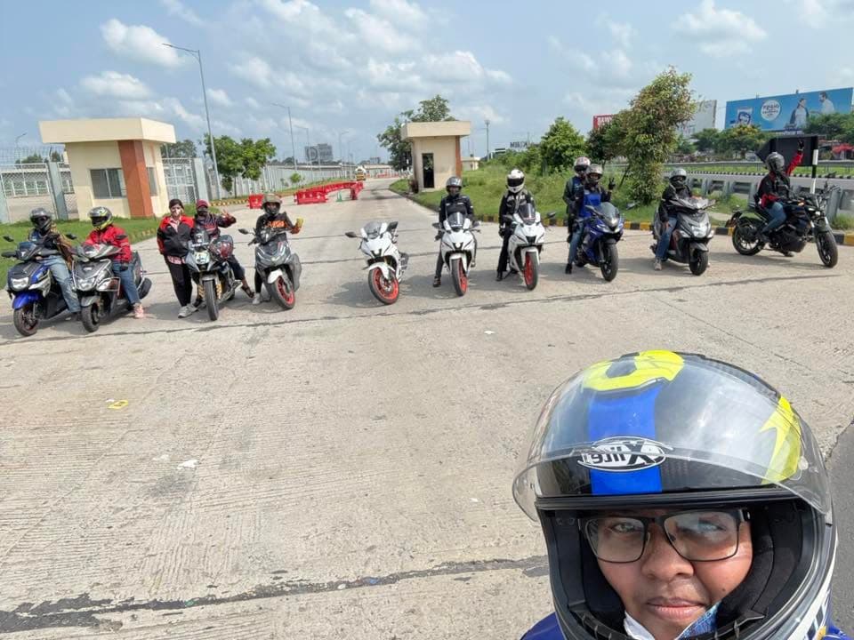 Riders in helmets taking a group selfie on a tour.