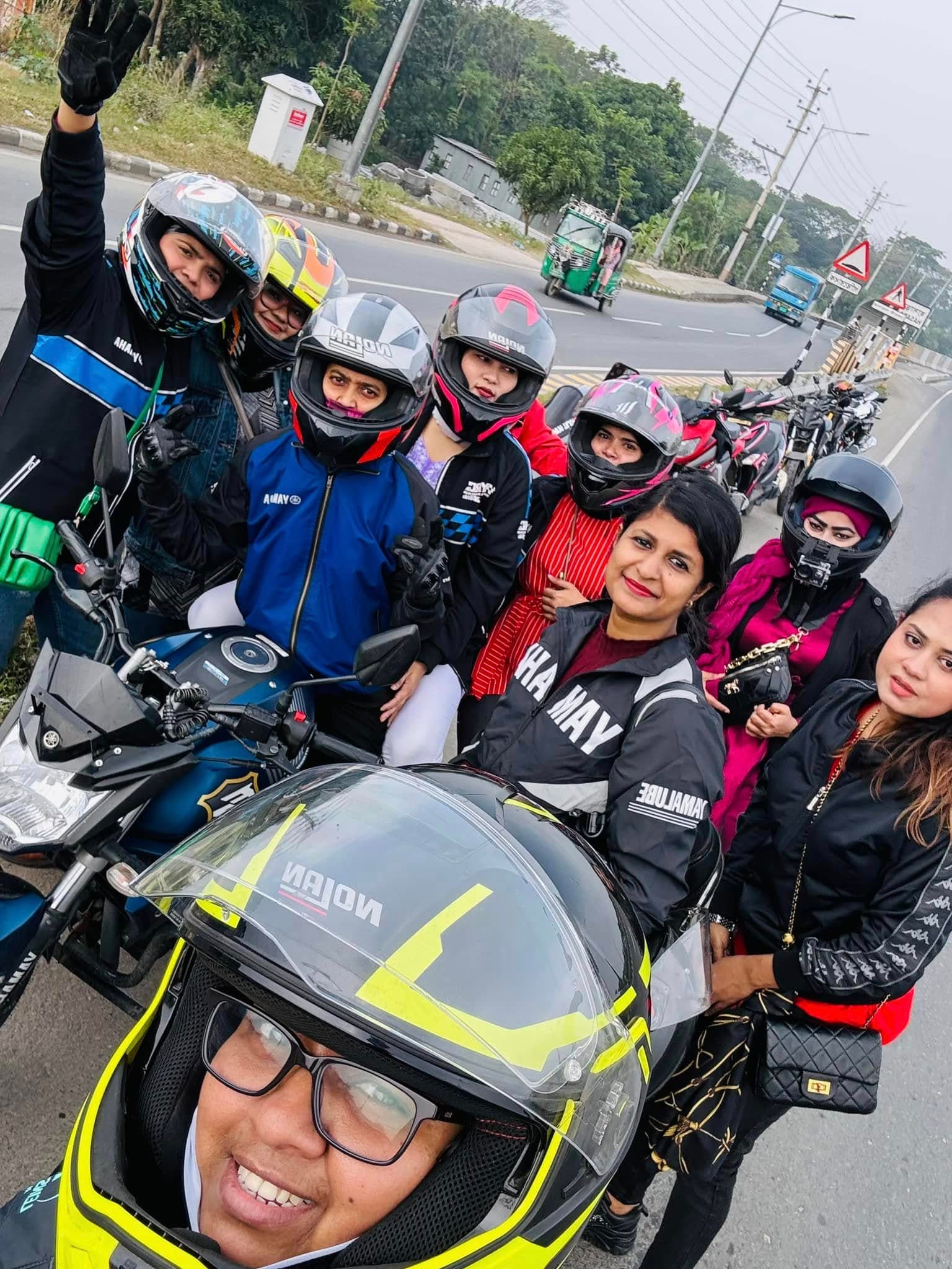 A group of riders taking a selfie beside the highway on a tour.