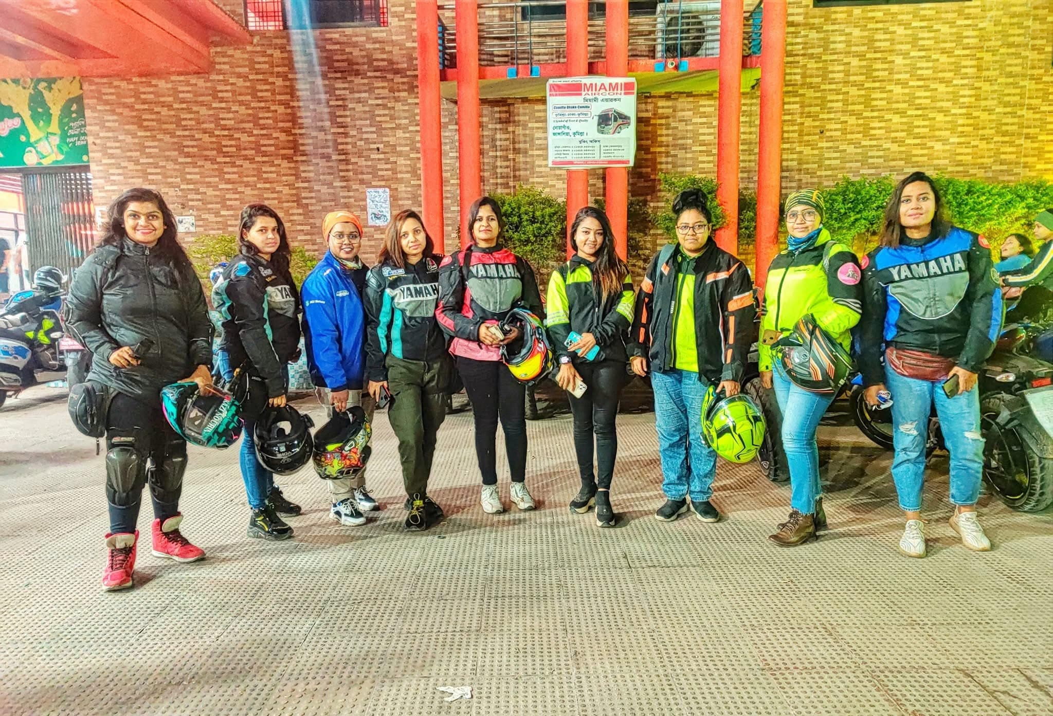 A group of riders together at night with their motorcycles.