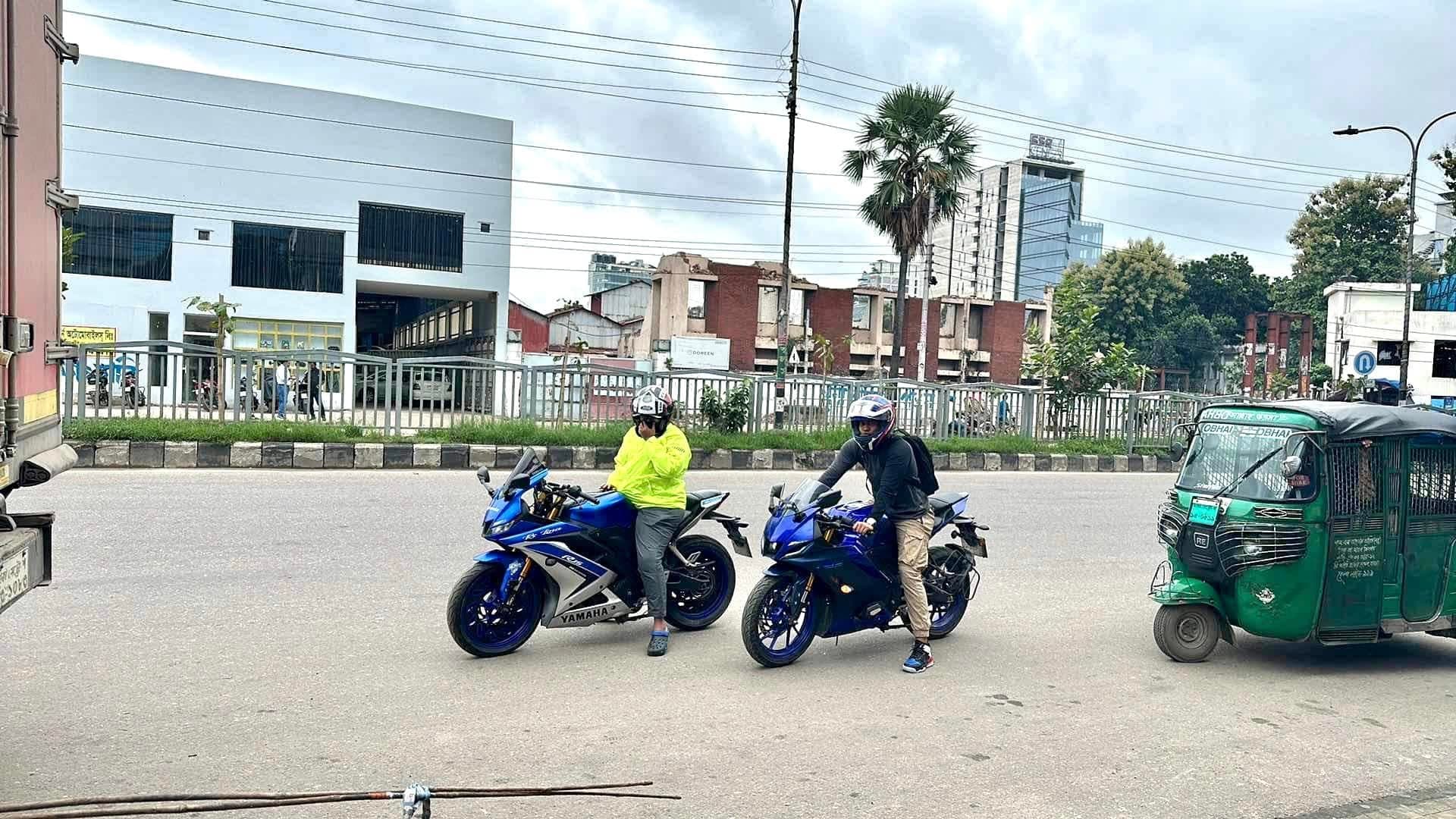 Two riders on Yamaha R15 motorcycles on a city road.