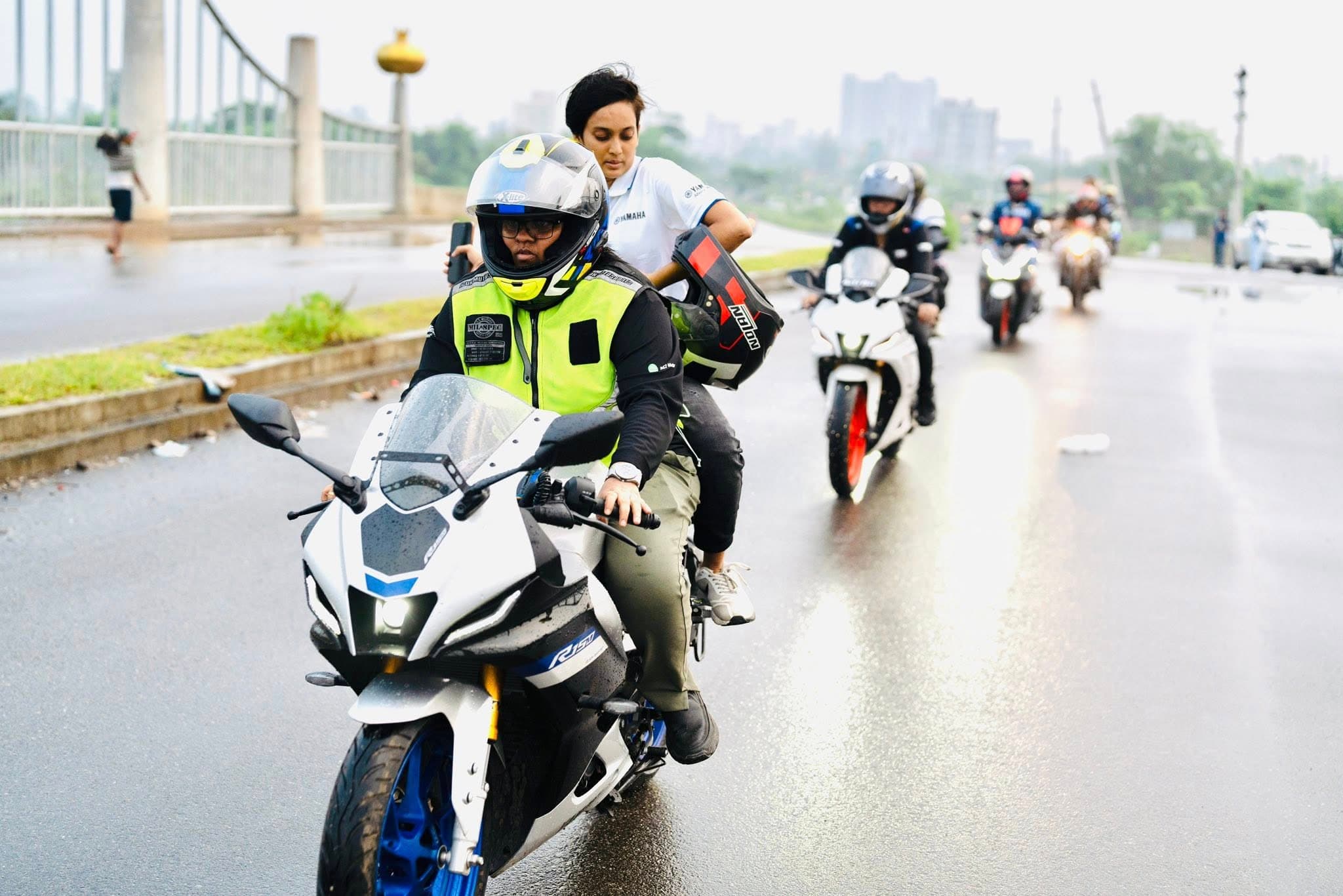 The lead motorcycle of a group tour, riding in the rain.
