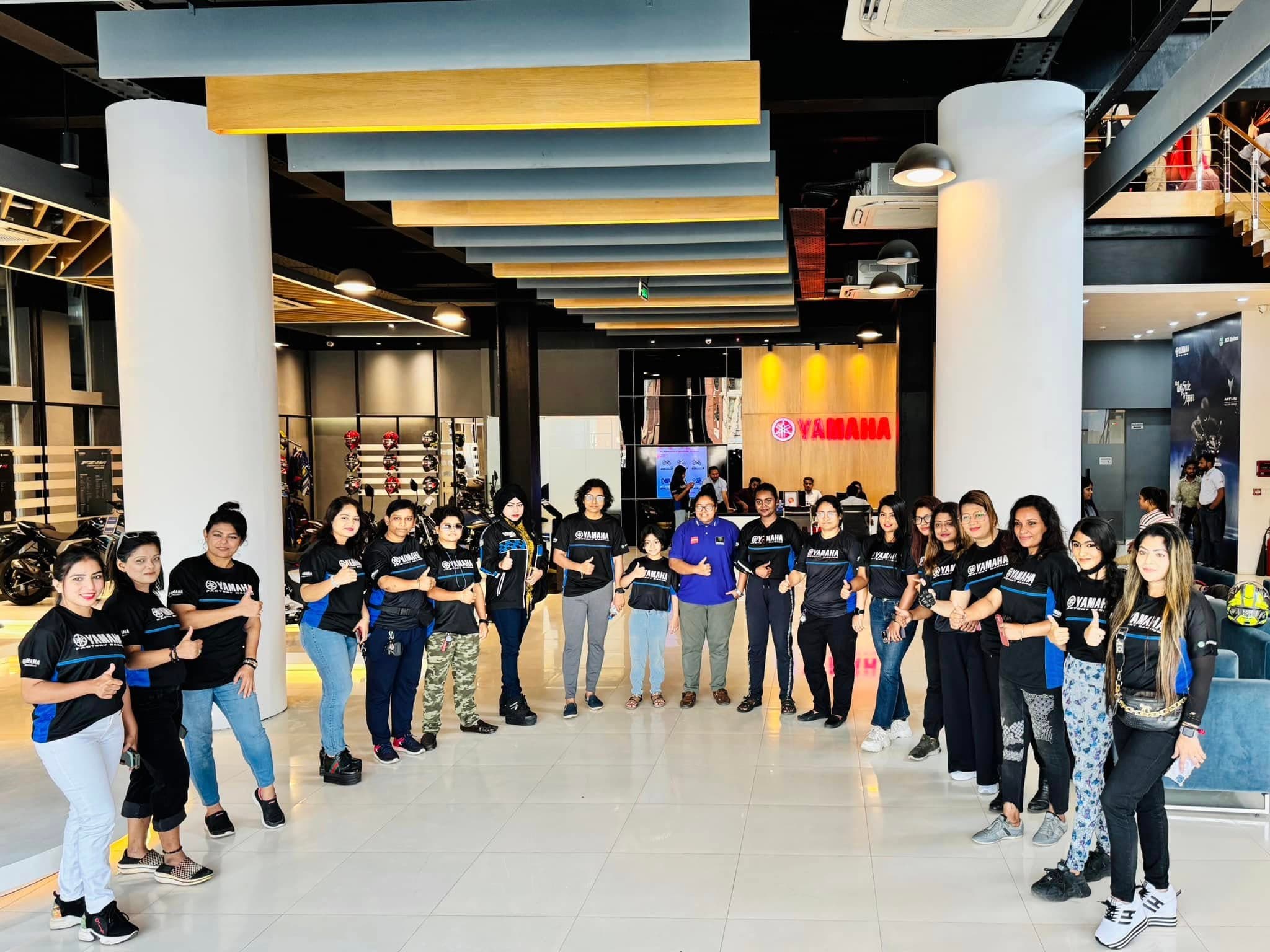 Women riders gathered inside the Yamaha showroom before a ride.