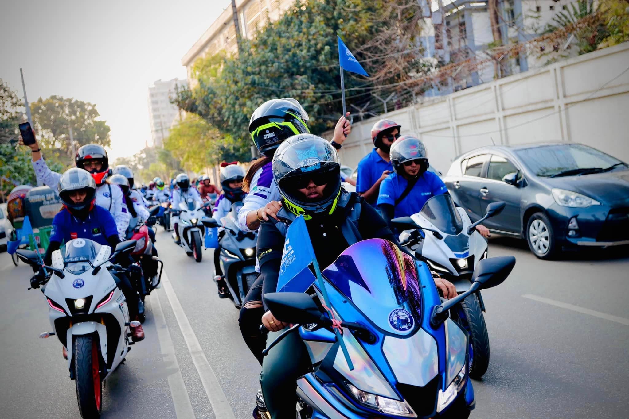A convoy of motorcycles riding together in a Women's Day rally.