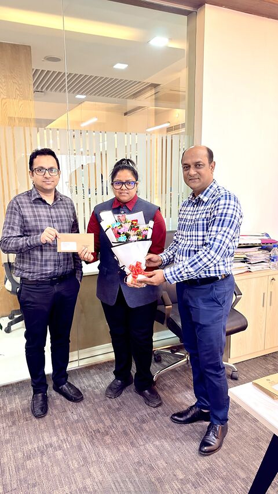 Razia Sultana Lina, in the center, receiving flowers and a letter at her promotion to Manager, ACI Motors Ltd.